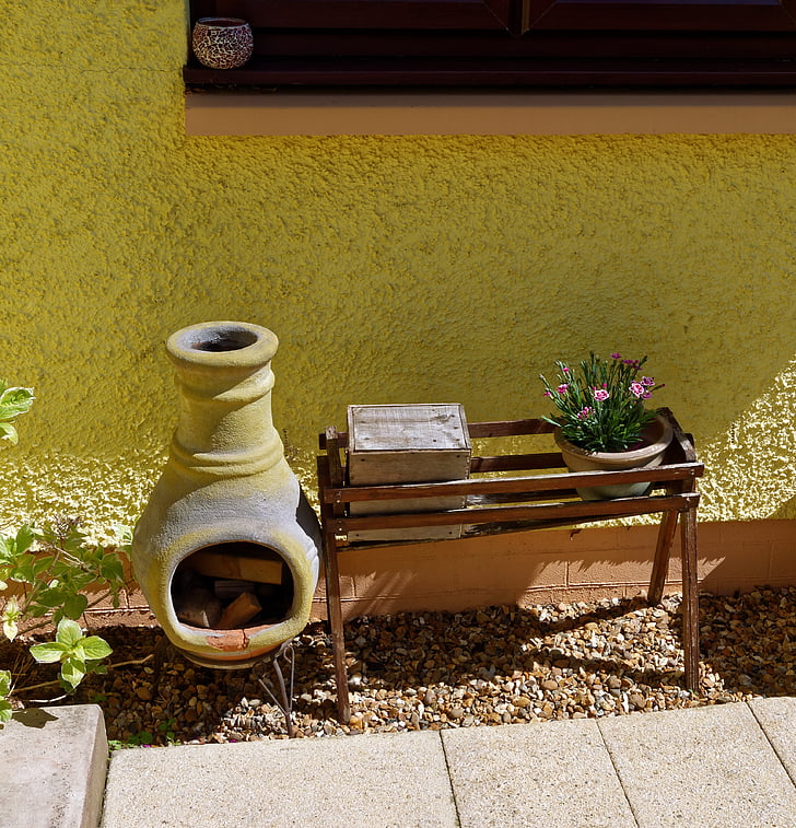 Small chiminea beside a wooden planter