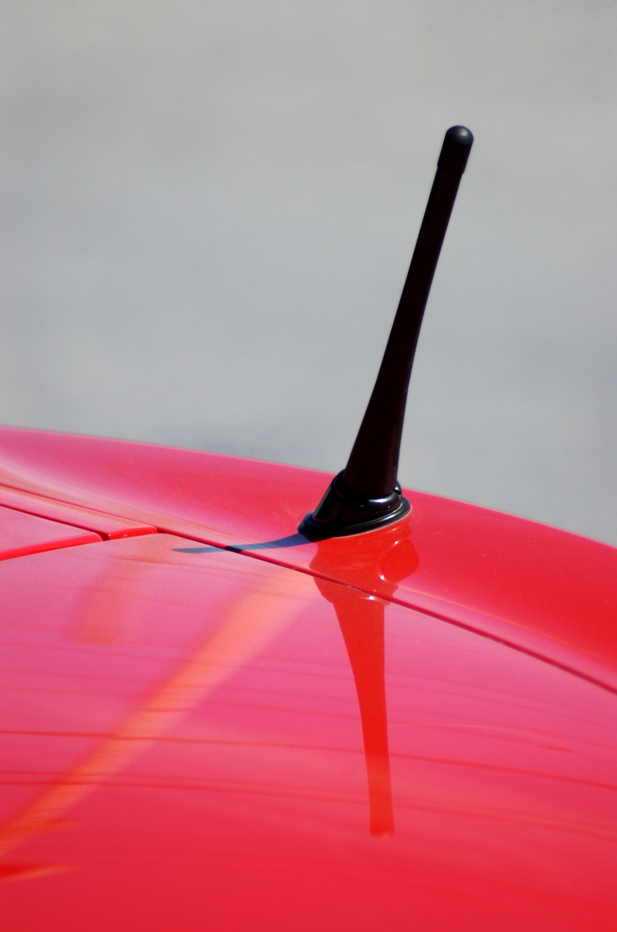 A red car's radio antenna up close