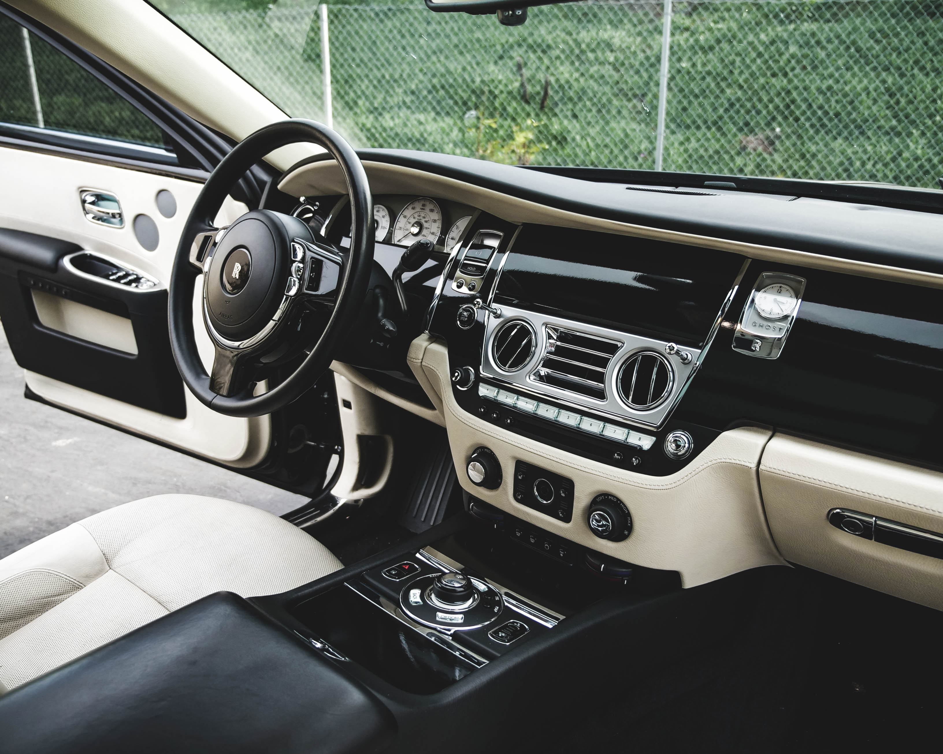 Luxury car interior with white leather seats and shiny dashboard