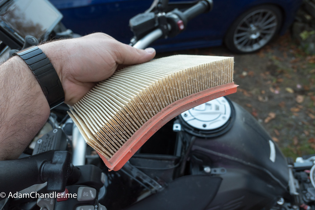 A person holding an engine air filter