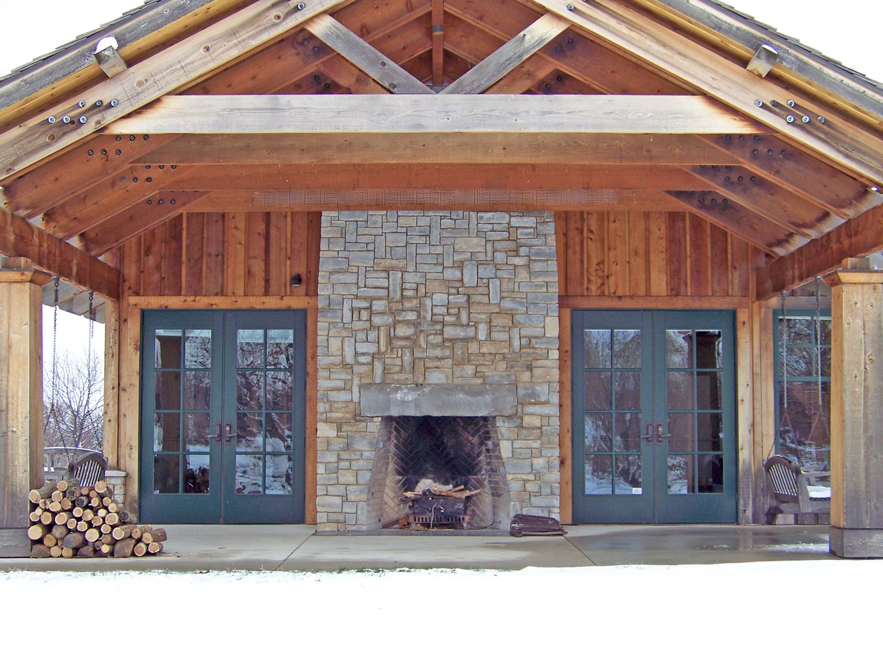 Outdoor stone fire place on a roof-covered patio