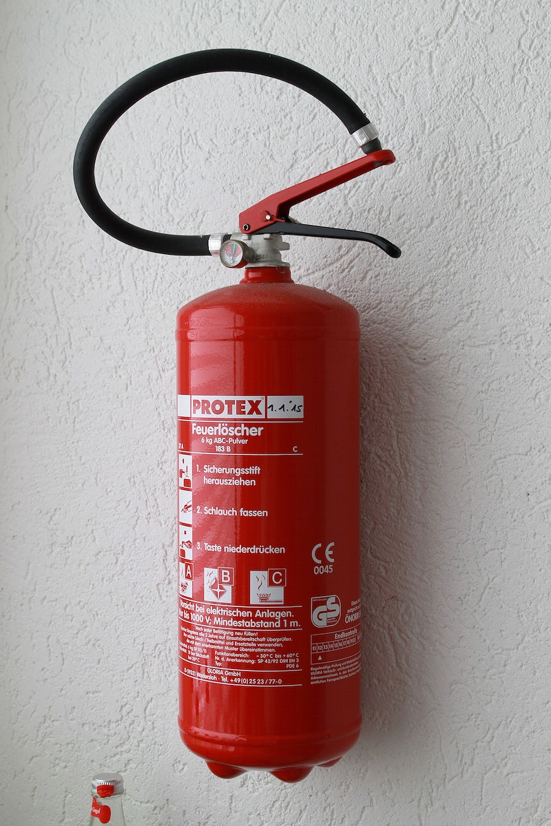 Fire extinguisher attached on a white wall