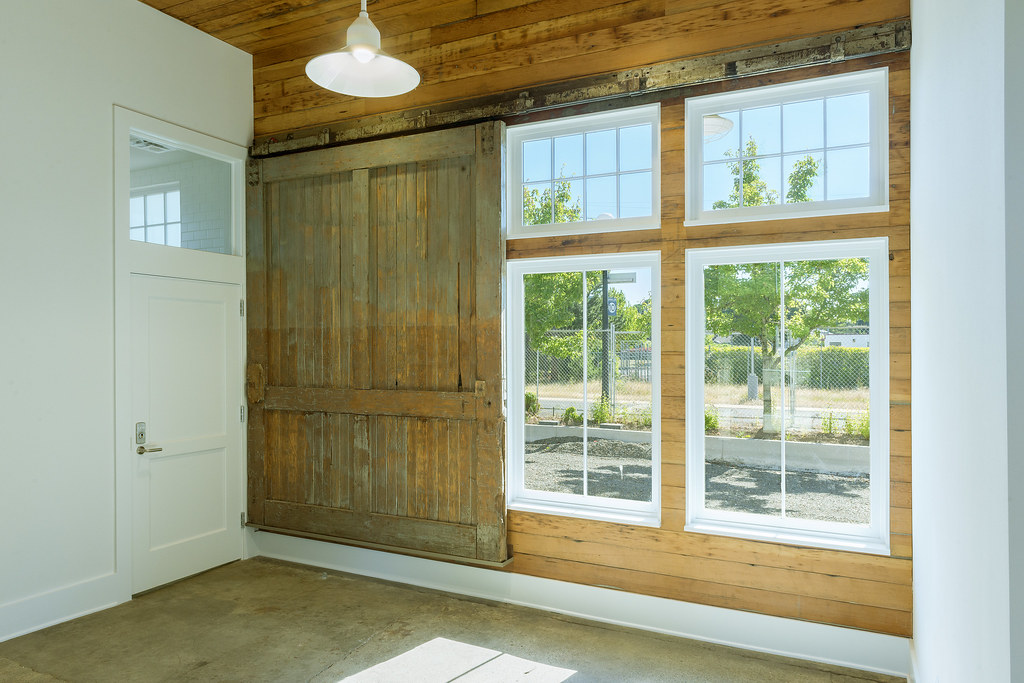 Shiplap wall with barn-like front door and massive windows