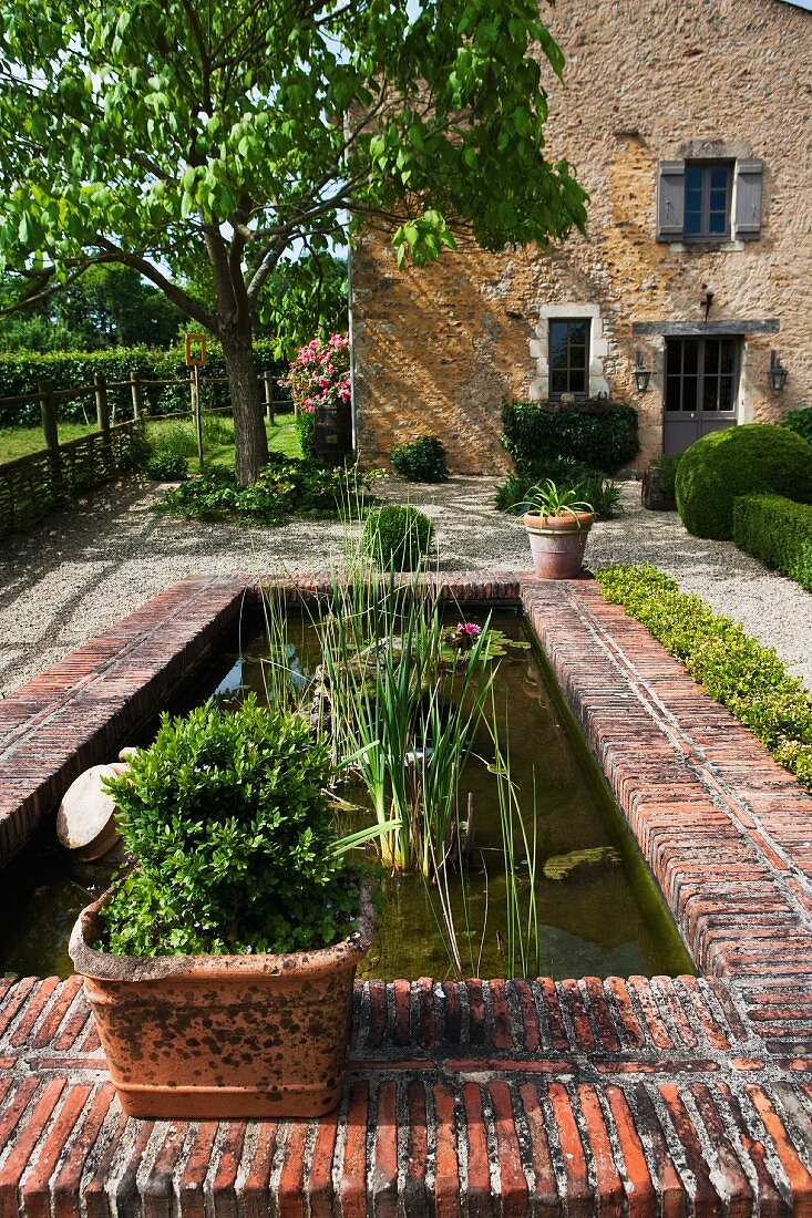 French garden design with a brick pond centrepiece