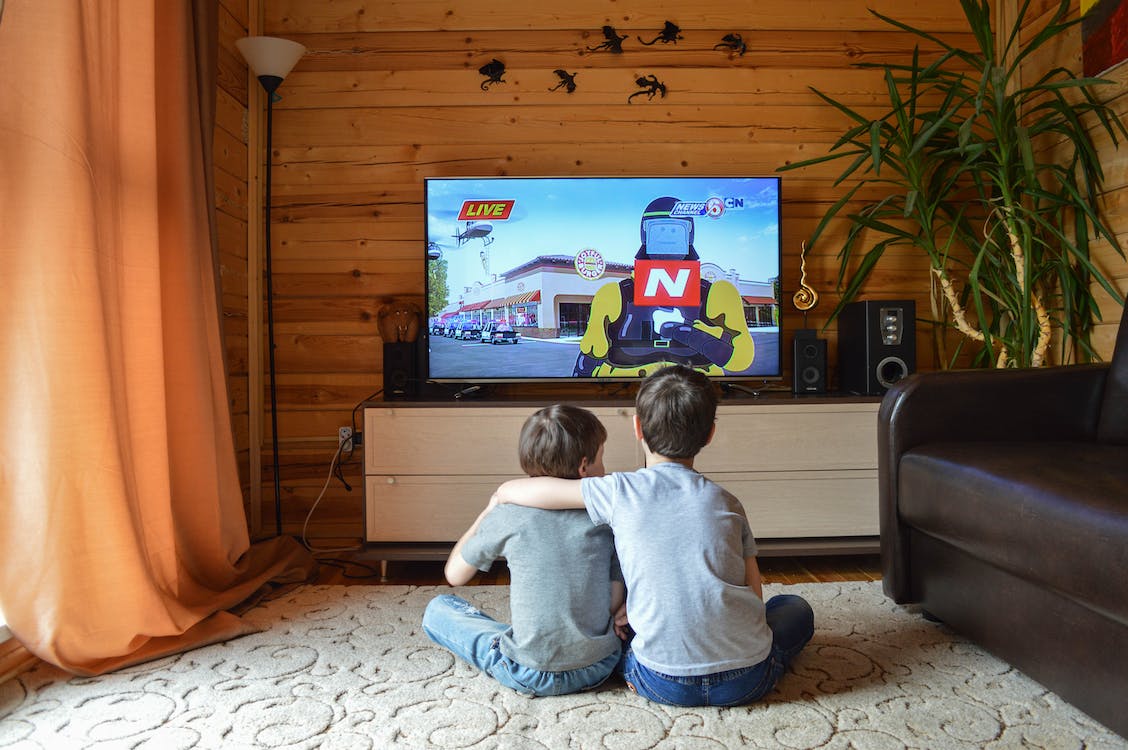 Two kids watching TV in a cabin
