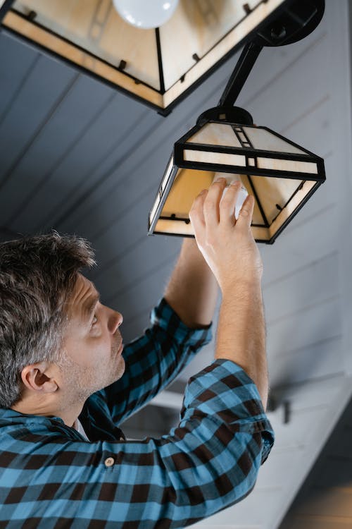 A man fixing a pendant light