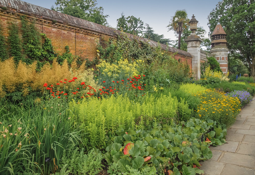 A courtyard's side showcasing lined, mixed borders of autumn annuals.