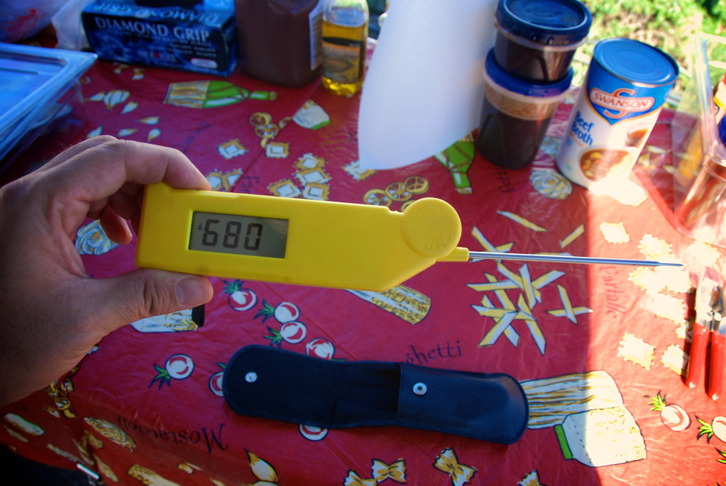 A person holding a yellow Thermapen for BBQ