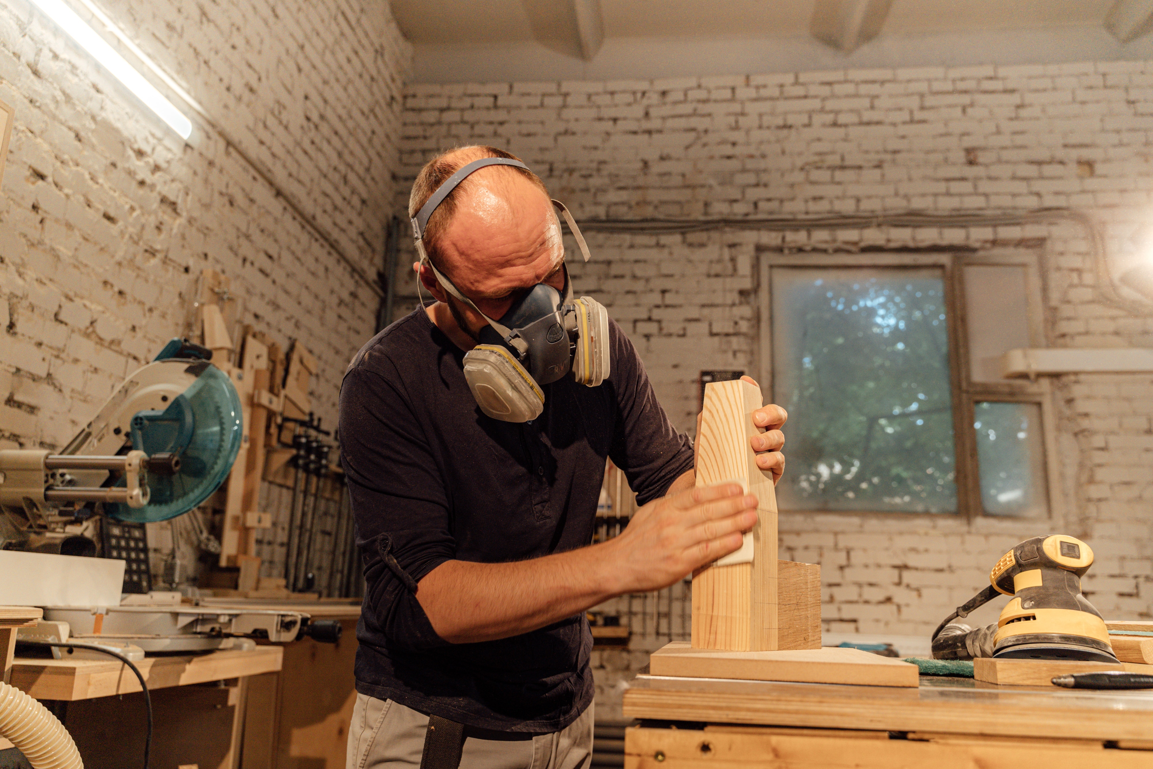 A handyman wearing a respirator mask while woodworking