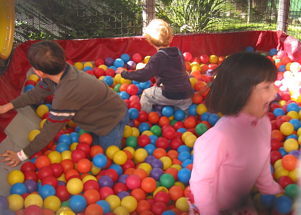 Happy kids playing in a DIY ball pit in the garden