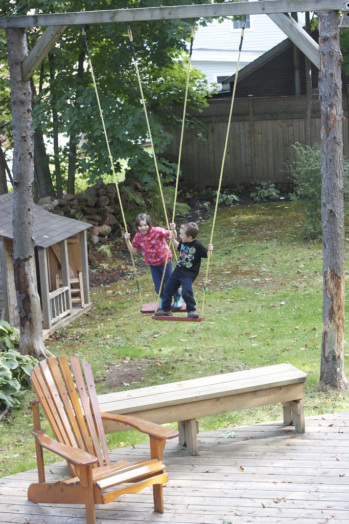Two kids on a garden swing