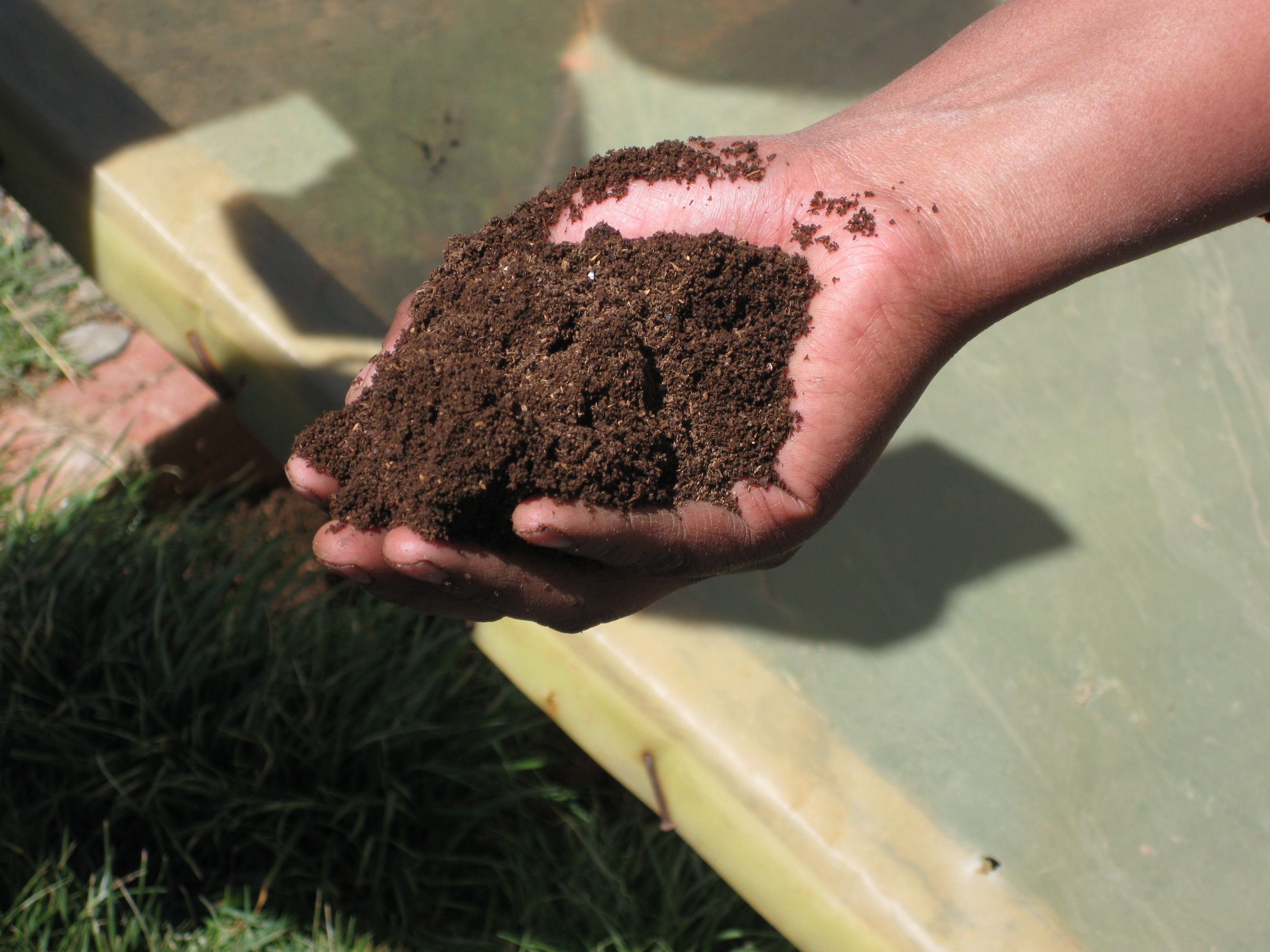 A person holding a compost with one hand