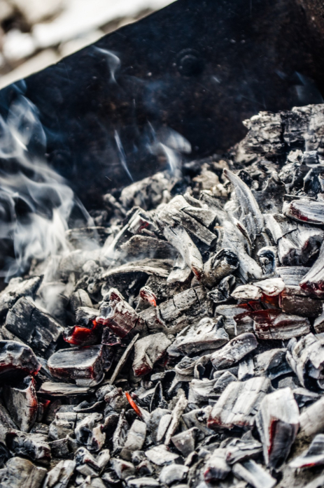 Lit charcoal covered in grey-white ash.