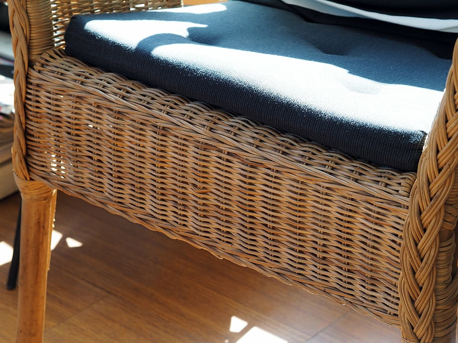 Close up shot of a rattan garden chair with cushion