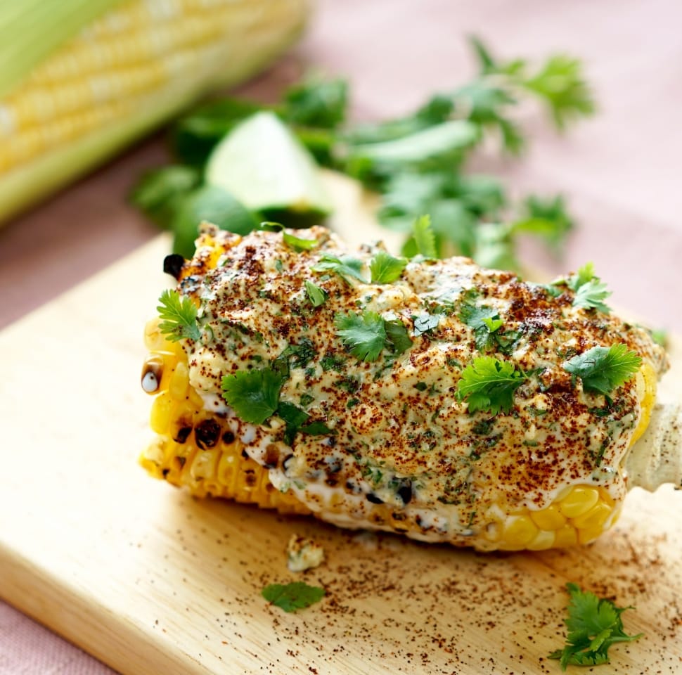 Grilled corn with cream and vegetable leaf toppings