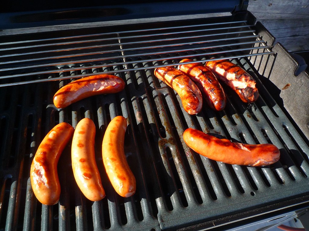 Grilling sausages on a gas BBQ.