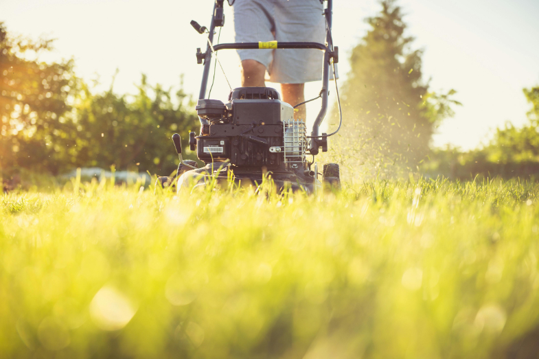 A person cutting grass with a lawn mower.