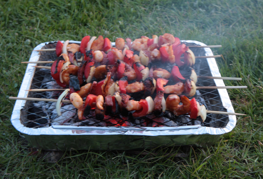 King prawn skewers on a disposable BBQ.