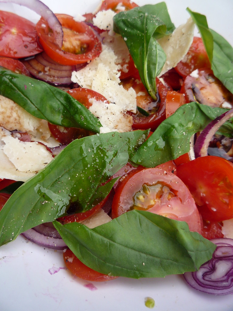 A mix of tomato, red onion, and basil salad.